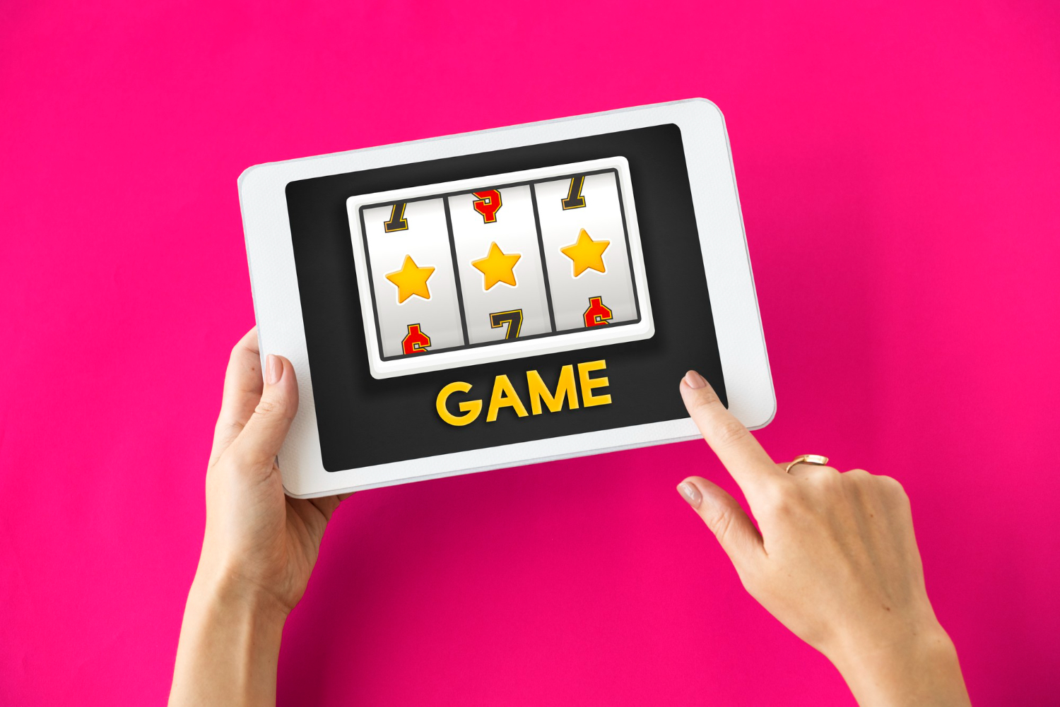 Female hands holding a tablet with a slot machine and a label saying Game on the display